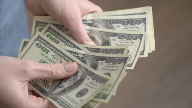 istock Close-up of female hands counting dollars 1434061914