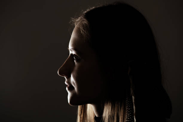 istock Low light side view of woman studio portrait 1434062097