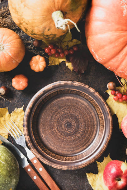 istock Thanksgiving day concept. Autumn table setting for dinner with plate, knife, fork decorated pumpkins and maple leaves. Flat lay autumn composition. 1434062534