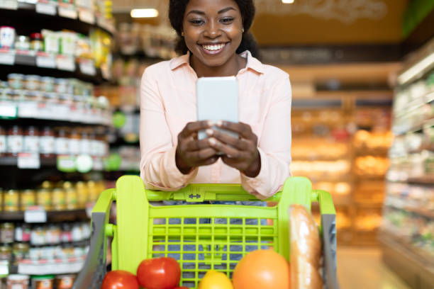 istock Happy Black Lady Using Phone During Grocery Shopping In Supermarket 1434065148