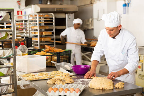 istock Male baker working with dough forming baguettes 1434066121