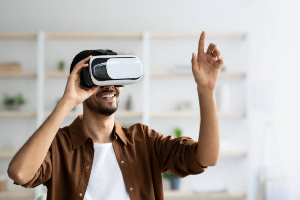 istock Young man using VR glasses, pointing at camera, closeup portrait 1434066699