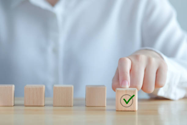 istock Elections and Voting, Vote, to do list, checklist, Task list, Survey and assessment concept. Hand pick green check mark on wooden block. 1434067202