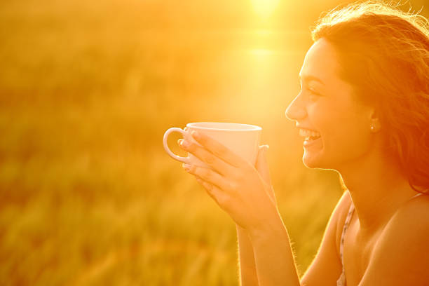 istock Happy woman laughing drinking coffee at sunset 1434067366