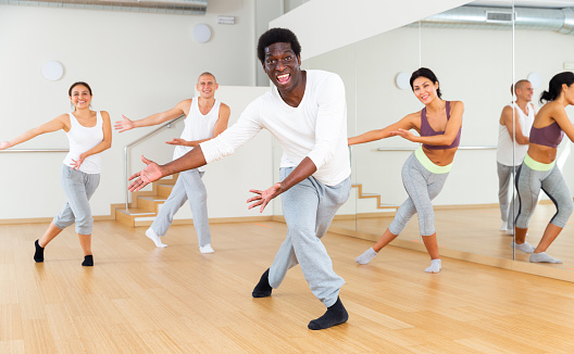 Cheerful male dancing and having fun during group dance class in fitness center