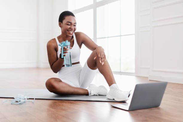 istock Young black woman woman talking with online coach using pc 1434068687