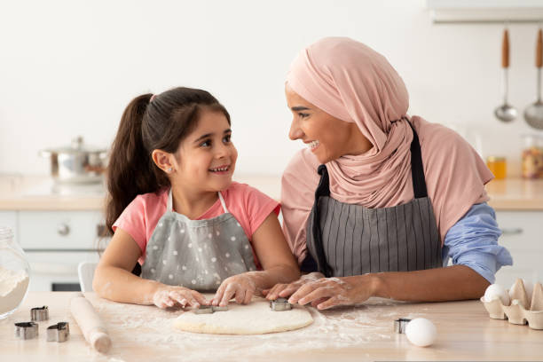 istock Smiling Muslim Mom With Her Little Daughter Baking Together In Kitchen 1434070925