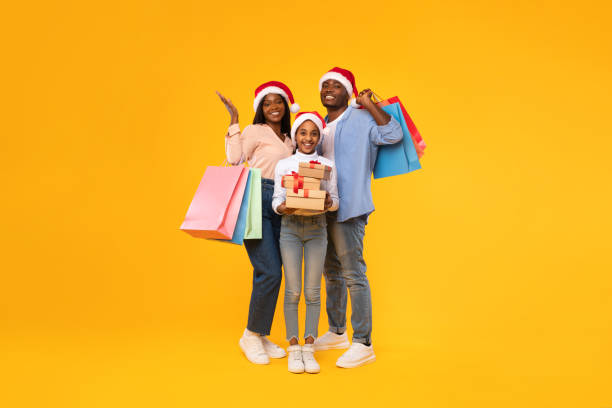 szczęśliwa czarna rodzina trzymająca torby na zakupy i świąteczne pudełka upominkowe - christmas bag shopping bag gift zdjęcia i obrazy z banku zdjęć