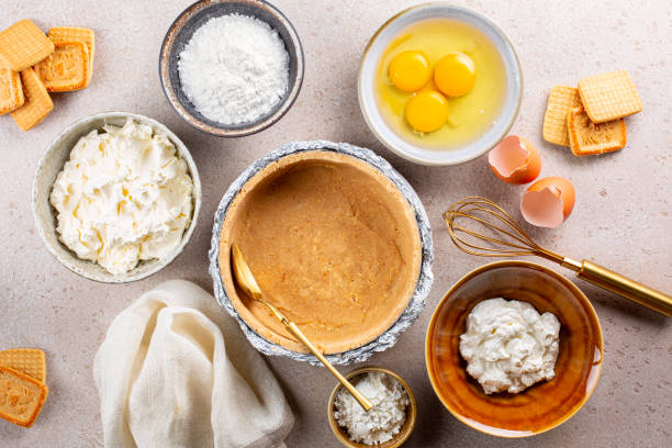 Cooking cheesecake. Main ingredients: soft, fresh cream cheese, eggs, sugar,  sour cream, corn starch. A bottom layer or base of pie made from crushed cookies. Top view.