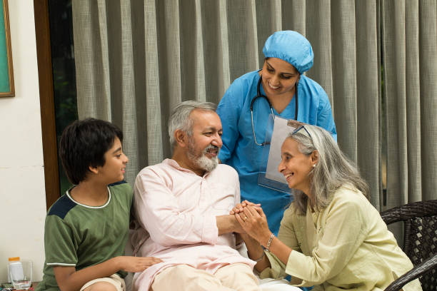 Nurse with happy family of old male patient Female nurse and family with senior patient sitting on bed your elderly loved one needs home care stock pictures, royalty-free photos & images