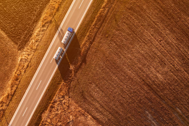 luftaufnahme eines zisternenwagens für den milchtransport, der am herbstnachmittag entlang der außerstädtischen landschaft fährt, drohnen-pov - truck fuel tanker semi truck milk tanker stock-fotos und bilder