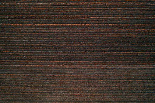 Aerial view of plowed field from drone pov, agricultural background and texture