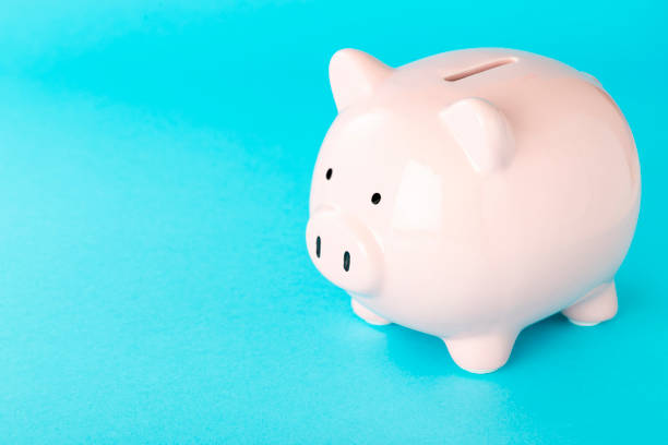 istock Side view of a piggy bank with copy space on blue background 1434075496