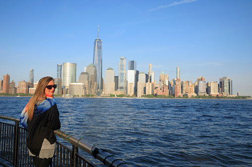 Pretty  active women Long blonde hair enjoying  in  Panorama of New York City skyline Lower Manhattan and the Freedom Tower Panoramic