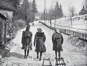 istock Three girls on their way to school with sleds in winter, schoolbags on their backs 1434076603
