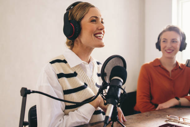 istock Happy female podcaster presenting a guest on her show 1434077291