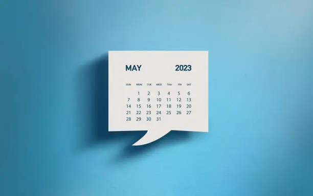 White chat bubble with cut out May 2023 calendar page over blue background. Easy to crop for all your social media and print sizes with copy space.