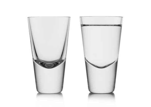 istock Full and empty shot glasses of pure clear cold vodka and tequila on white. 1434078603