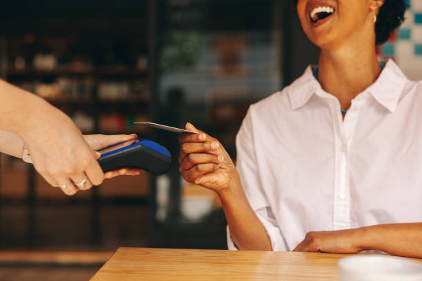 istock Happy customer paying her bill using a credit card 1434078775