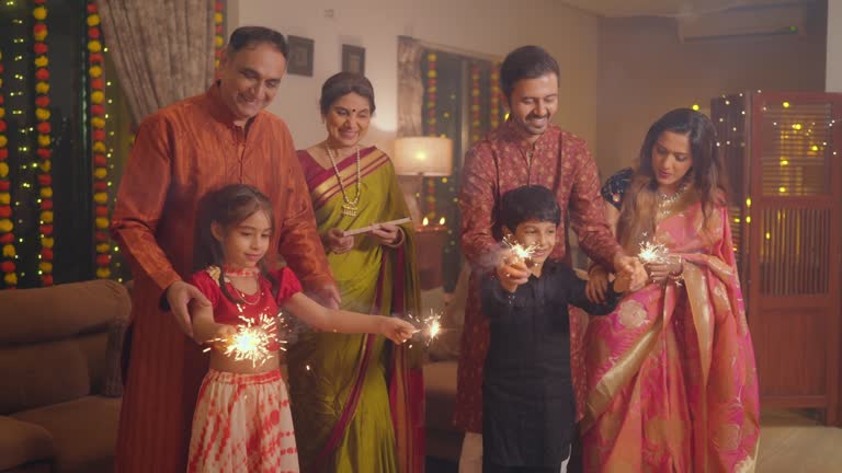 Indian happy kids playing with burning sparklers celebrating Diwali festival.