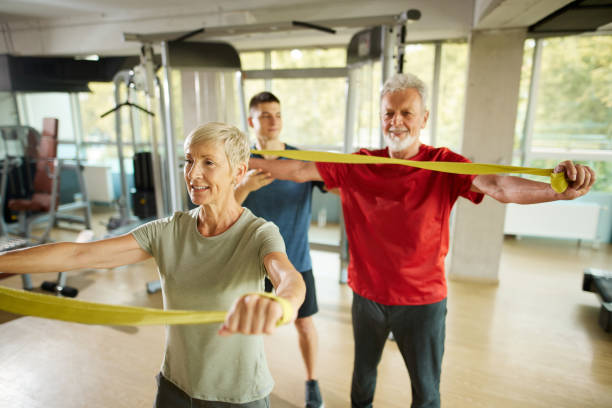 istock Senior couple exercising with personal trainer using resistance band 1434090476