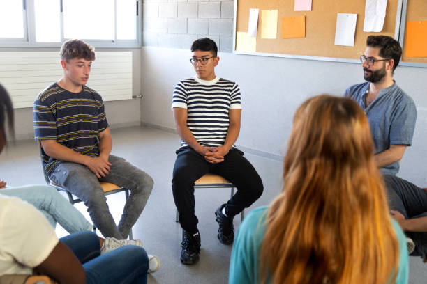 istock Multiracial students sitting in a circle sharing problems with classmates and teacher. High school support group. 1434091131
