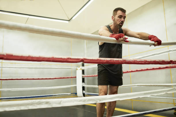 боксер восстанавливается на ринге после интенсивных боксерских спаррингов в тренажерном зале в буэнос-айресе - boxing ring фотографии стоковые фото и изображения