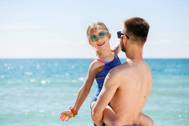istock Young dad hold daughter at sea beach 1434093611