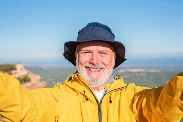 istock happy retired hiker taking a selfie hiking a mountain using his smartphone 1434095863