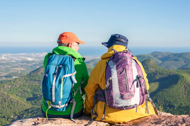 istock Two friends hikers sitting on top of a mountain with a great view. 1434096892