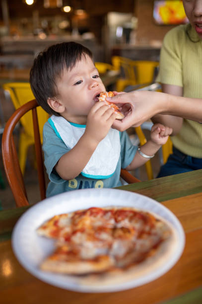 istock Infant baby boy having pizza in the restaurant 1434098063