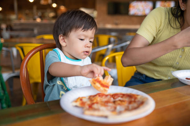 istock Infant baby boy having pizza in the restaurant 1434098336