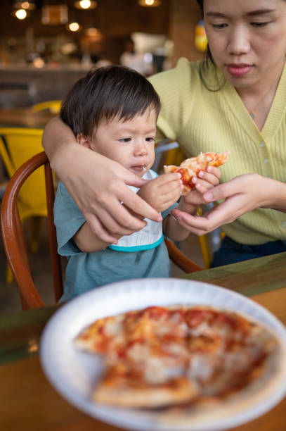 istock Infant baby boy having pizza in the restaurant 1434098441