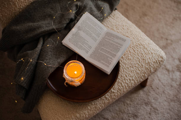 istock Reading book in bedroom with candle and knit cloth 1434102906