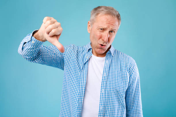 istock Senior man showing thumbs down sign gesture 1434104482