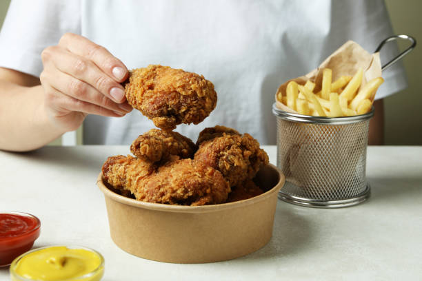 istock Concept of tasty eating with fried chicken on white textured table 1434105247