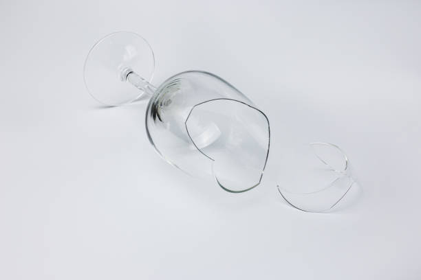istock Broken wine glass with a shard on a light isolated background 1434105931