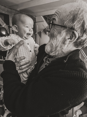 Granddad holding his baby grandson in his arms