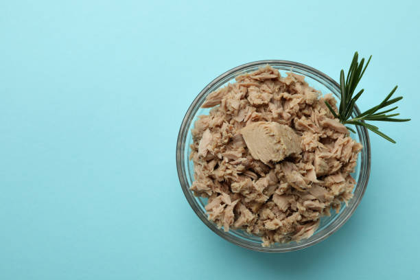 istock Glass bowl with canned tuna on blue background 1434110213