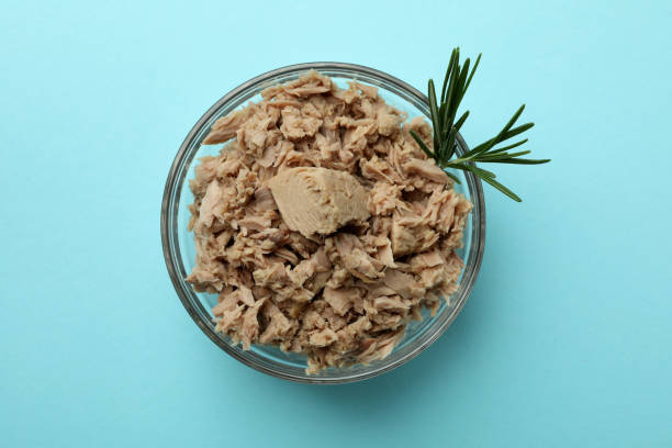 istock Glass bowl with canned tuna on blue background 1434110446