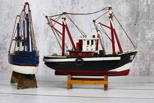 Wooden model of a fishing boat on a stand. Decoration on the shelf, collecting ships.