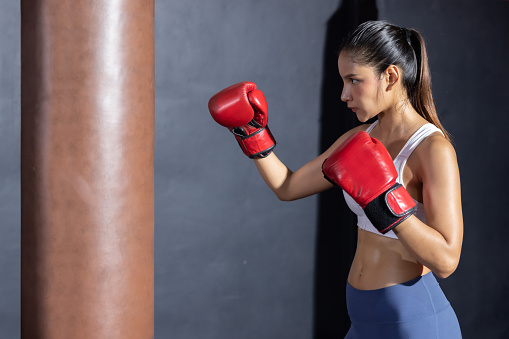 Side View of Asian Woman with Red Boxing Glove  Ready for Boxing Match