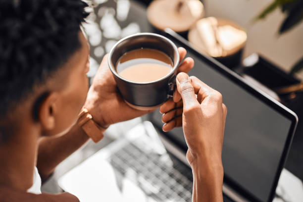 istock Coffee, laptop and break with a black man blogger enjoying a drink while doing remote work as a freelance writer. Computer, internet and startup with a male entrepreneur working on his online blog 1434114733