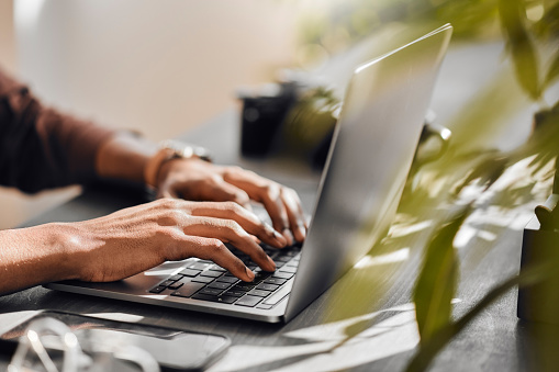 Black man typing on laptop, contact us online and computer technology for ecommerce website. Writing email on keyboard, person searching internet and employee working with 5g connection at desk