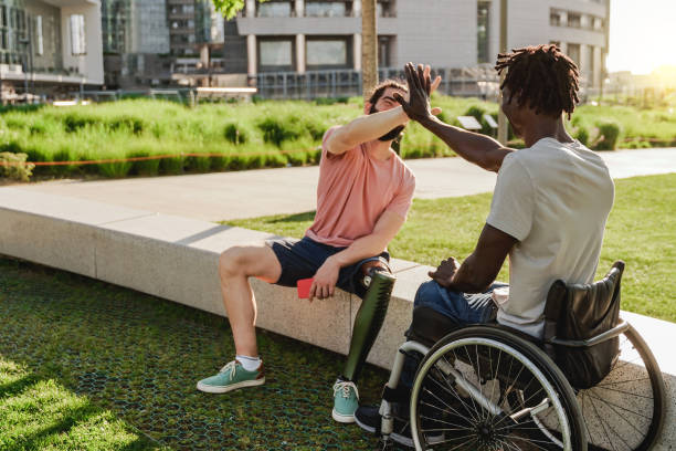 istock Multiracial people with physical disabilities greeting each other outdoor - Focus on right man sitting on wheelchair 1434114912