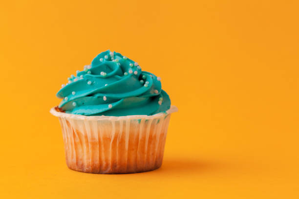 istock Delicious cupcakes with icing on a yellow background 1434116000