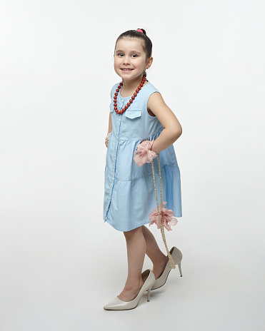 little black-haired fashionista in high-heeled shoes. funny photo shoot in the studio on a white background.