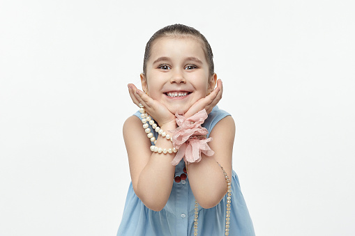 the little black-haired fashionista tucked her head in her hands. funny photo shoot in the studio on a white background.