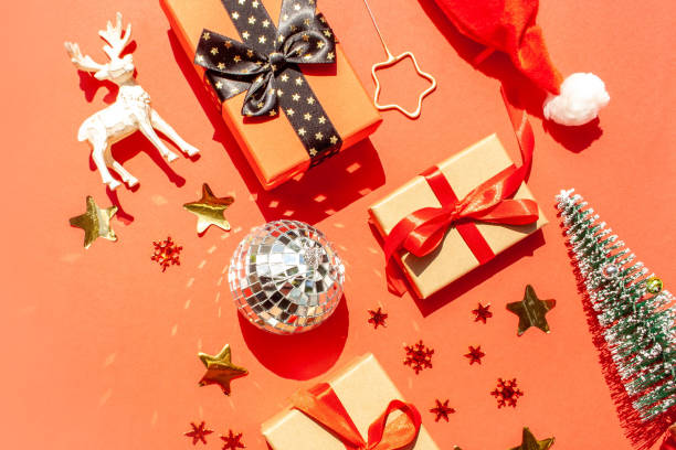 istock Christmas and New Year decorations on a red background. Christmas deer, gift boxes, tree and santa hat. Flat Lay style 1434117368