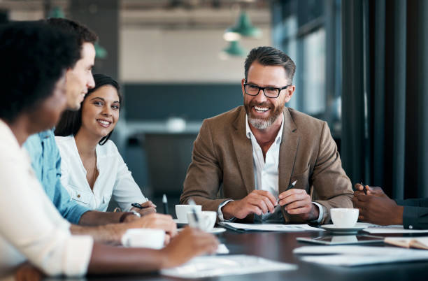 teambuilding, glückliche und geschäftsleute, die in einem meeting lachen, nachdem sie erfolgreich wachstumsstrategieideen geplant haben. lächeln, vielfalt und ceo, der mit einer gruppe von mitarbeitern oder arbeitern über einen lustigen witz spricht - business ceo building activity business person stock-fotos und bilder